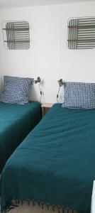 a bedroom with two beds with green blankets and pillows at "Mar e sou" 412 Camping La Réserve SIBLU in Gastes