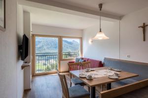 a living room with a dining room table and a window at Thusnelda Apartment B in Siusi