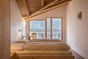 1 Schlafzimmer mit 2 Betten und einem Balkon in der Unterkunft Thusnelda Apartment B in Seis am Schlern