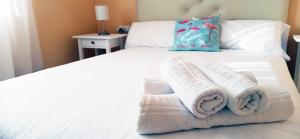 a bedroom with a bed with towels on it at Mshome Mirada al Mediterráneo in Rincón de la Victoria