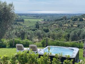 a hot tub on a hill with two chairs at Relais dei Molini in Castagneto Carducci