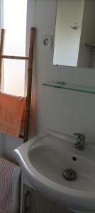 a bathroom with a white sink and a mirror at "Mar e sou" 412 Camping La Réserve SIBLU in Gastes