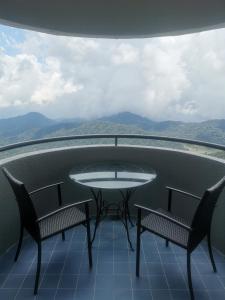 雲頂高原的住宿－5-6 PAX Family Room Skyview Golden Hills, Genting Highlands，美景阳台配有一张桌子和两把椅子