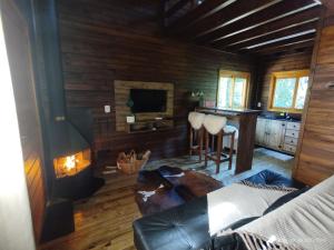 a living room with a fireplace in a log cabin at Cabanas dos Plátanos in Gramado