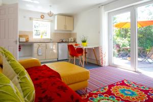 a kitchen with a couch and a table with an umbrella at Krissie's in Marazion