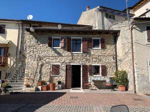 stary kamienny dom z drzwiami i schodami w obiekcie Holiday Home Casa Stella - Casa Susanne by Interhome w mieście Spiazzi Di Caprino