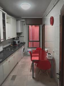 a kitchen with a red table and red chairs at Vivienda Turística en el casco antiguo VUT-LE- 566 Corazón del Barrio Húmedo in León