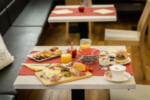 una mesa con comida para el desayuno y bebidas en ella en Boutique Exclusive B&B, en Trento