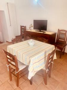 uma mesa e cadeiras com uma mesa e uma televisão em Trullo House em Locorotondo