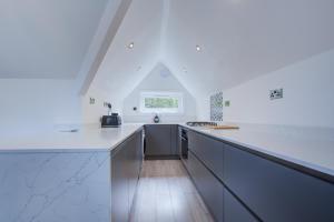 uma cozinha com bancadas brancas e uma janela em Luxury 3 Bedroom Apartment Close to Beach, Bournemouth & Meyrick Park em Bournemouth