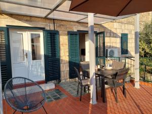 a patio with a table and chairs and an umbrella at Apartment Saul in Cavtat