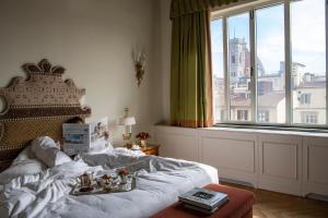 a bedroom with a white bed and a large window at Helvetia&Bristol Firenze – Starhotels Collezione in Florence