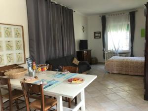 a living room with a table and a room with a bed at Da Scilla in Punta Marina