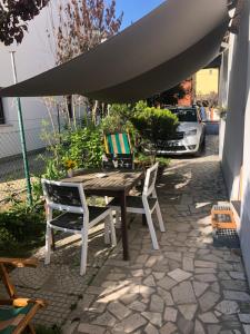 a wooden table and two chairs under an umbrella at Da Scilla in Punta Marina