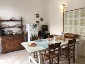 a kitchen with a white table and chairs and a refrigerator at Da Scilla in Punta Marina