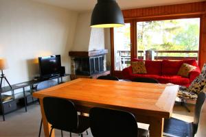 シオンにあるOrée du Bois PLEASANT & COSY apartmentsのリビングルーム(テーブル、赤いソファ付)
