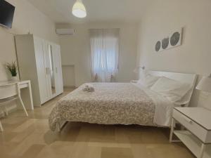 a white bedroom with a bed and a desk at Guest House Service - Game Apartment in Modugno