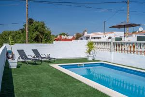 a backyard with a swimming pool and green grass at VILLA XOROI in Cala en Porter