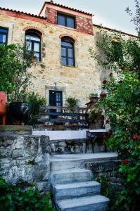 a building with stairs and a bench in front of it at Cretan Village House elborgini in Veneráton