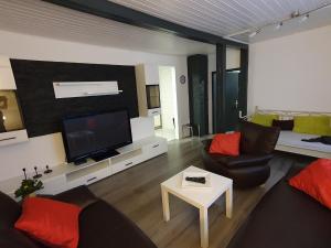 sala de estar con sofá y TV en Ferienwohnung Bei Vogel, en Geroldsgrün