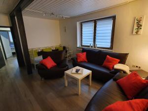 Sala de estar con 2 sofás y mesa en Ferienwohnung Bei Vogel, en Geroldsgrün