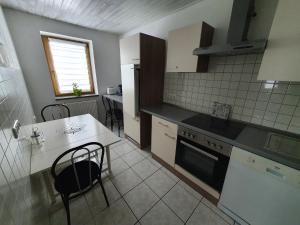 a kitchen with a table and a stove top oven at Ferienwohnung Bei Vogel in Geroldsgrün