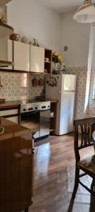 a kitchen with a white refrigerator and a kitchen table at Appartamenti Il Leone in Pienza
