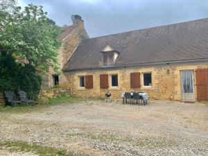 an old stone house with a grill in front of it at Maison chaleureuse à la campagne in Payrignac