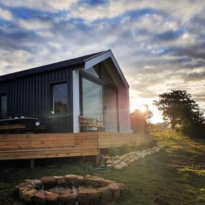 a small house with a wooden deck and the sunset at Hillandale Hideaway in Plettenberg Bay