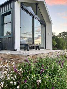 a house with a picnic table on a deck with flowers at Hillandale Hideaway in Plettenberg Bay