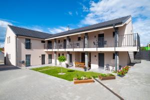 an apartment building with a balcony and a courtyard at Vinařství Herůfek in Zaječí