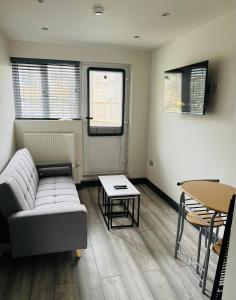 een woonkamer met een bank en een tafel bij Green Lantern, Private En-suite Double Bedroom in Aveley