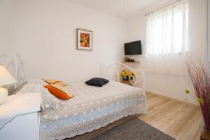 1 dormitorio blanco con 1 cama y TV en Studio Gabi, Premantura, en Premantura
