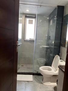 un bagno con wc e doccia in vetro di Windchime 853 a Gurgaon Altre 12 foto