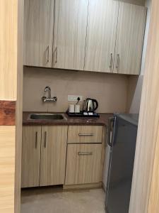 a small kitchen with a sink and a refrigerator at Windchime 853 in Gurgaon