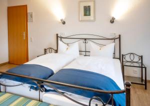 a bedroom with two beds with blue and white sheets at Hotel Haus Nachtigall - B&B in Uedem