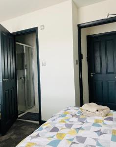 a bedroom with a bed and two black doors at Green Lantern, Private En-suite Double Bedroom in Aveley