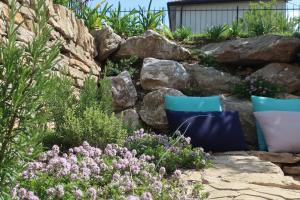 a garden with blue and white pillows and rocks at Picobello Lago in Mandello del Lario