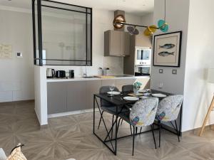 a kitchen with a black table and chairs in a room at Skyline - Penthouse with 50m2 private terrace and stunning views in Cádiz