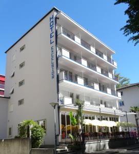 Ein weißes Gebäude mit einem Schild drauf. in der Unterkunft Hotel Excelsior in Locarno