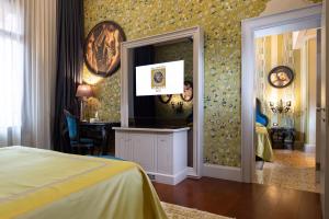1 dormitorio con TV en la pared en Palazzetto Madonna, en Venecia