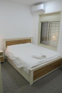a bedroom with a large bed with a window at Hermon Suites in Majdal Shams