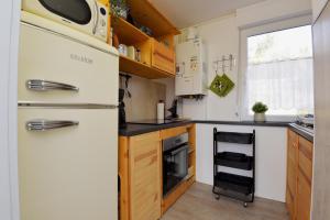 una cucina con frigorifero bianco e piano cottura di Ferienhaus am Fusse des Rennsteig/ Haus Anna a Suhl