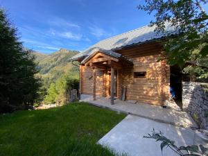 ein Blockhaus mit einem Rasenplatz davor in der Unterkunft Alpenchalet Grabner Alm am Präbichl in Almhäuser