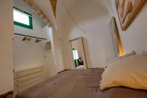 a bedroom with a large bed in a room with a window at Dimora Clessidra in Patù