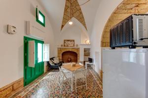 a living room with a table and a green door at Dimora Clessidra in Patù