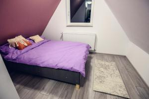 a small bedroom with a purple bed with a mirror at Cabana Zabet in Ranca