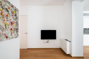 ein Wohnzimmer mit einem TV an einer weißen Wand in der Unterkunft Santo Stefano Design Apartment by Wonderful Italy in Bologna