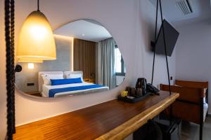 a bedroom with a bed and a mirror at Casa Porto Boutique Hotel - Adults only in Agios Nikolaos