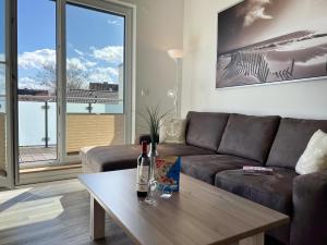 - un salon avec un canapé et une table dans l'établissement ZUM LEUCHTTURM Wellness-Appartement APPARTO Grömitz, à Grömitz